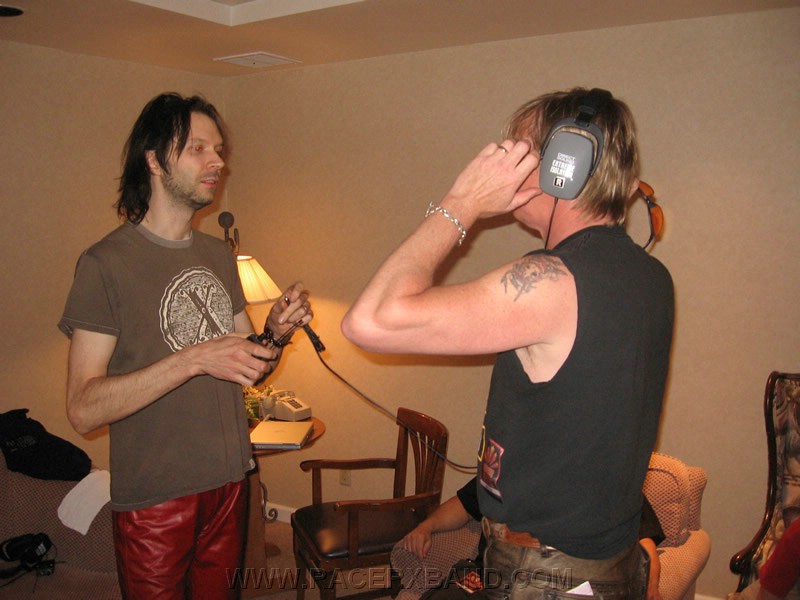 24. Paul shows Jeff his wireless headset and listens to Joe Satriani's set from the board..jpg